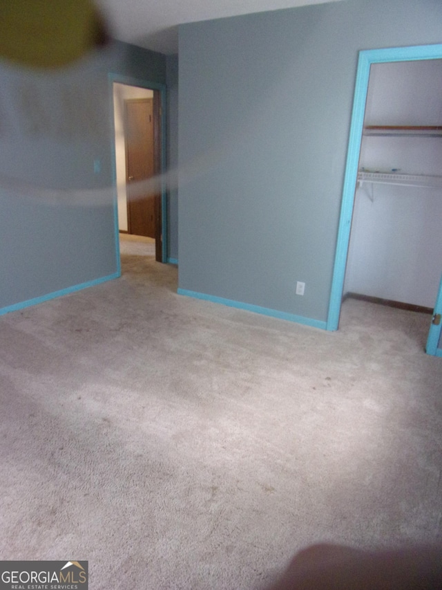 unfurnished bedroom with a closet, baseboards, and carpet floors