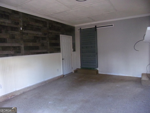 spare room featuring a barn door and carpet