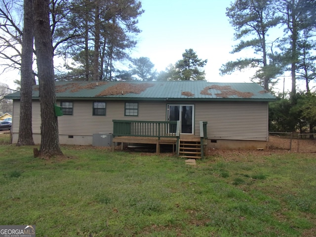 rear view of house featuring crawl space, a lawn, a wooden deck, and metal roof