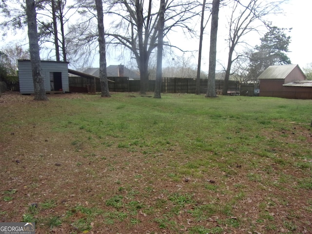 view of yard featuring an outbuilding and fence