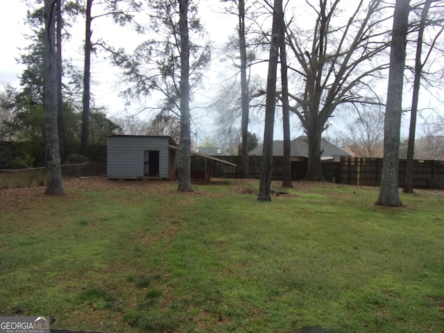 view of yard featuring a fenced backyard, a storage unit, and an outdoor structure