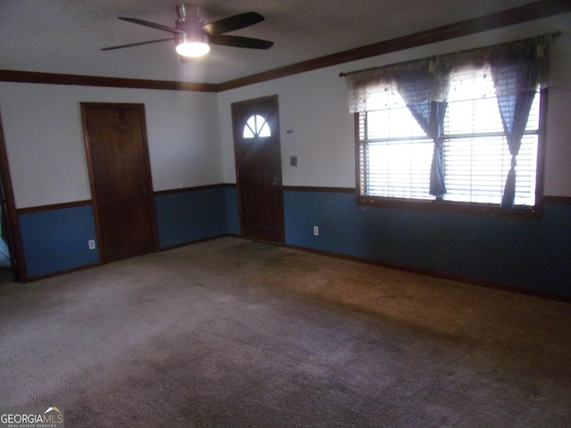 interior space featuring a ceiling fan, light colored carpet, and crown molding