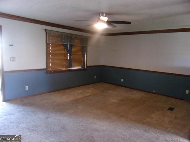 carpeted empty room featuring crown molding and ceiling fan