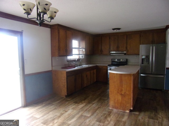 kitchen featuring light countertops, wood finished floors, under cabinet range hood, and stainless steel appliances