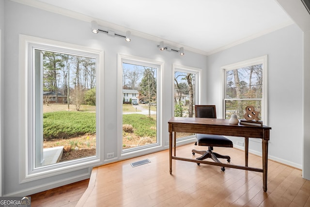 home office with visible vents, crown molding, baseboards, rail lighting, and wood finished floors