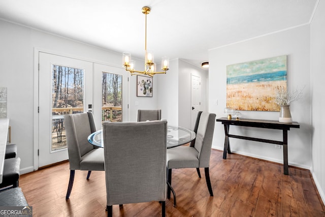 dining room with baseboards, an inviting chandelier, and wood finished floors