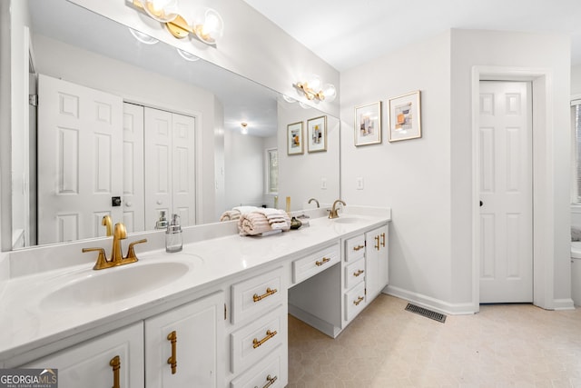 full bathroom featuring double vanity, visible vents, baseboards, and a sink