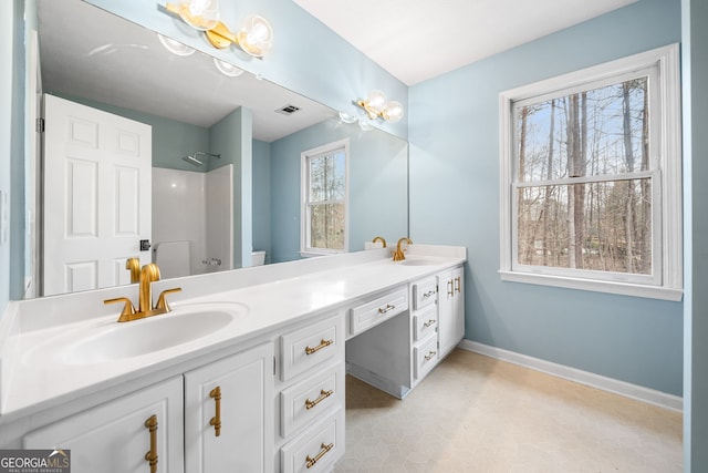 full bath with double vanity, visible vents, baseboards, and a sink