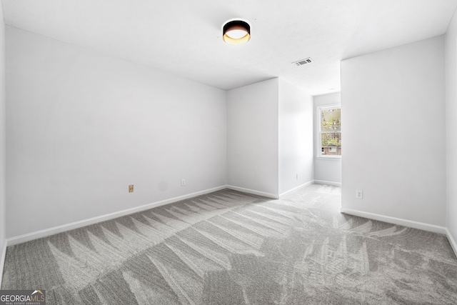 carpeted spare room with baseboards and visible vents