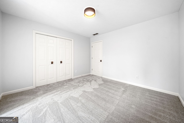 unfurnished bedroom featuring visible vents, baseboards, a closet, and carpet flooring