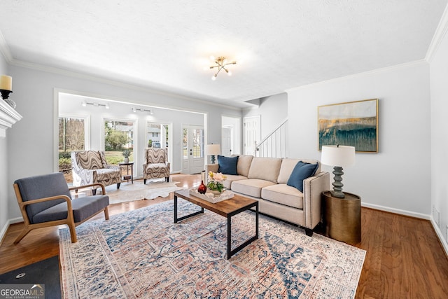 living room with a textured ceiling, wood finished floors, and ornamental molding