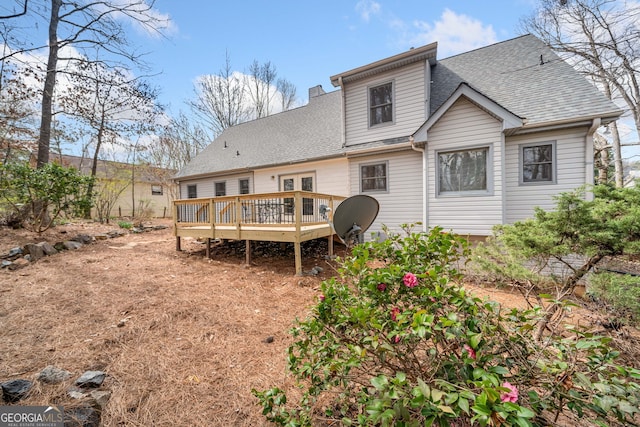 rear view of house with a shingled roof and a wooden deck