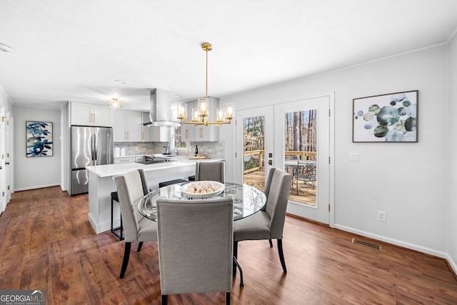 dining space with an inviting chandelier, baseboards, visible vents, and dark wood-type flooring