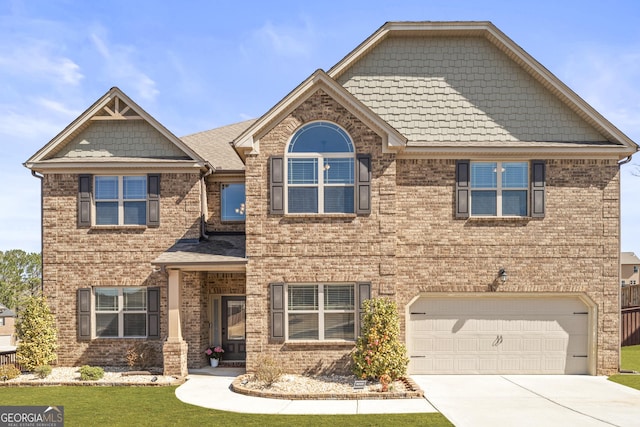 craftsman-style home featuring brick siding, a front lawn, an attached garage, and driveway