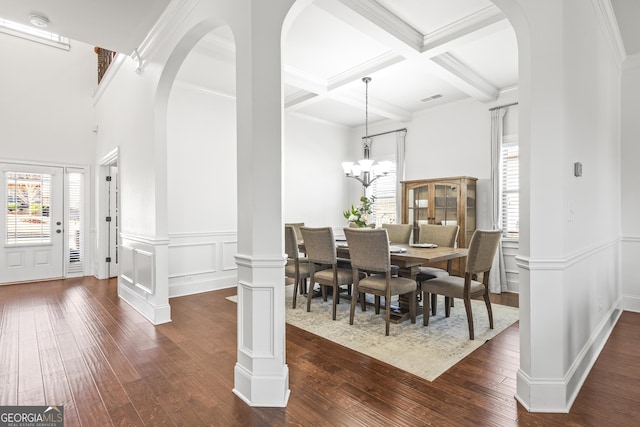 dining room featuring arched walkways, beam ceiling, coffered ceiling, and dark wood-style floors