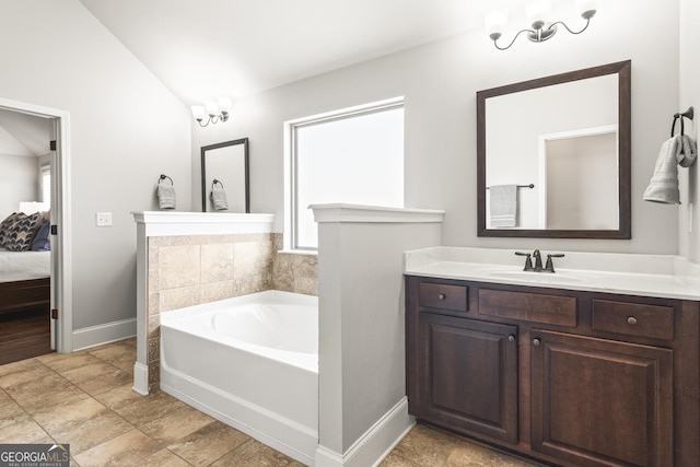 ensuite bathroom with vanity, baseboards, ensuite bath, vaulted ceiling, and a garden tub