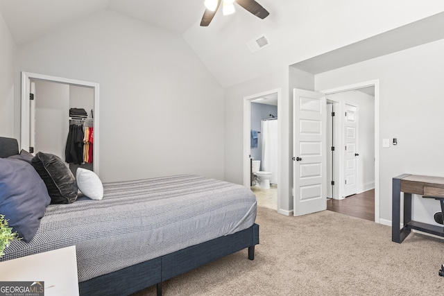 bedroom with visible vents, a walk in closet, ensuite bathroom, carpet, and lofted ceiling