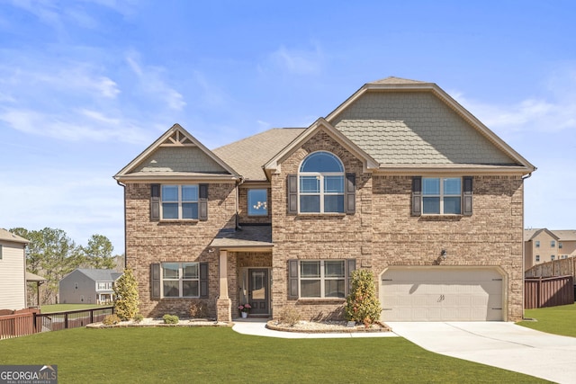 craftsman-style house featuring a front yard, fence, and driveway