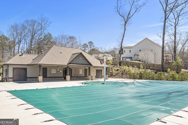 community pool with a patio and fence