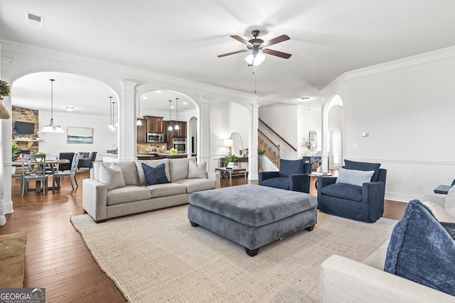 living room with visible vents, arched walkways, wood-type flooring, and ceiling fan