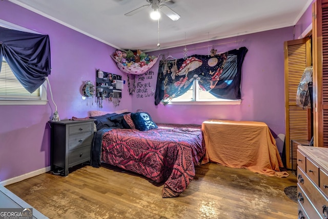 bedroom with ceiling fan, baseboards, wood finished floors, and ornamental molding