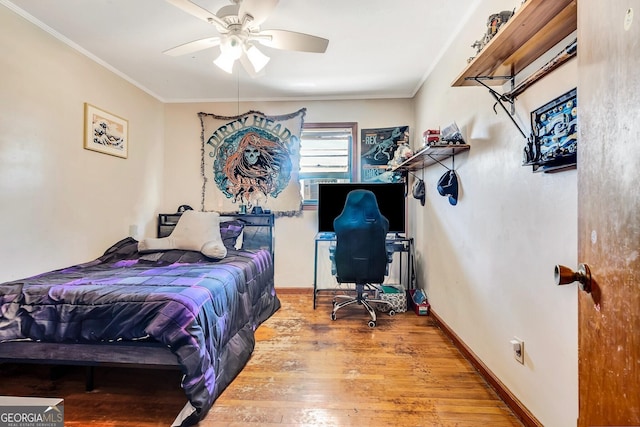 bedroom with ceiling fan, baseboards, wood finished floors, and crown molding