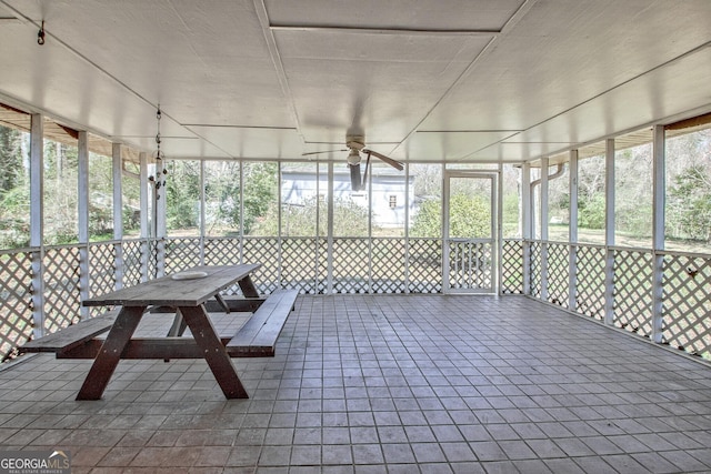 unfurnished sunroom with ceiling fan