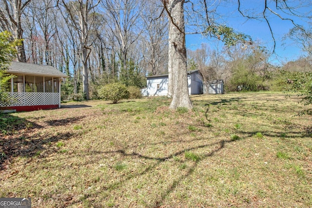 view of yard with an outbuilding and a sunroom