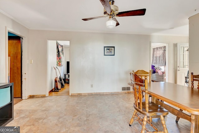 dining space with visible vents, baseboards, a ceiling fan, and ornamental molding