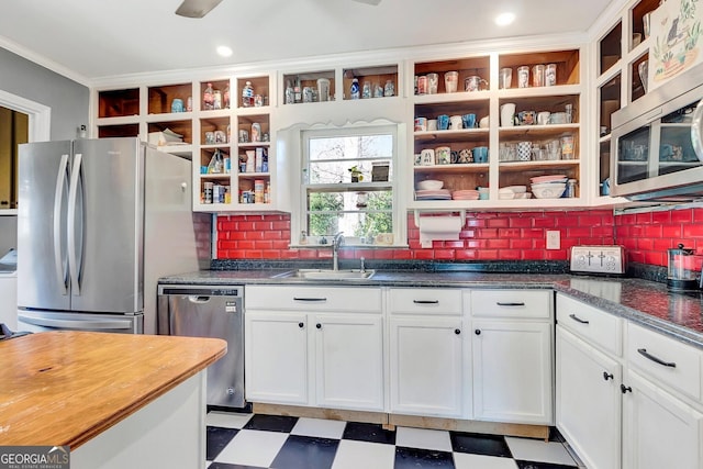 kitchen featuring tile patterned floors, open shelves, stainless steel appliances, and a sink