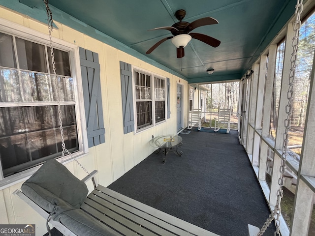 unfurnished sunroom featuring ceiling fan