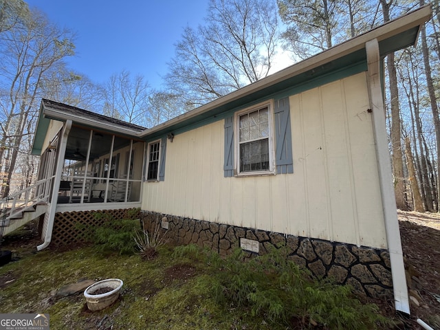 view of side of property featuring stairs and a sunroom