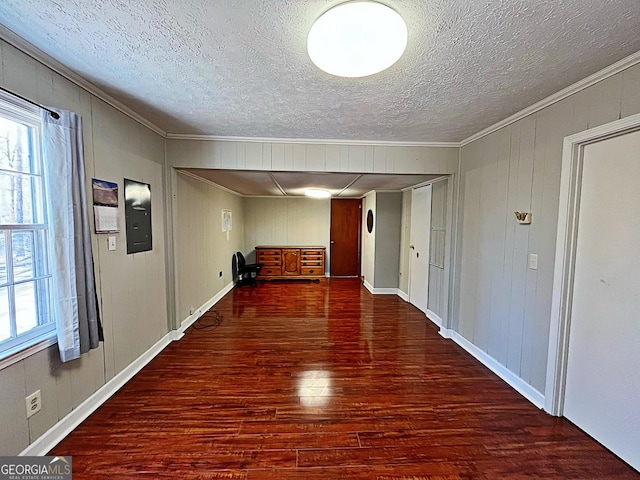 interior space featuring a textured ceiling, wood finished floors, and ornamental molding