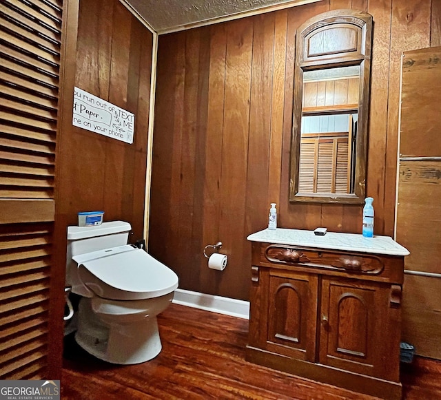 bathroom with wooden walls, wood finished floors, and toilet