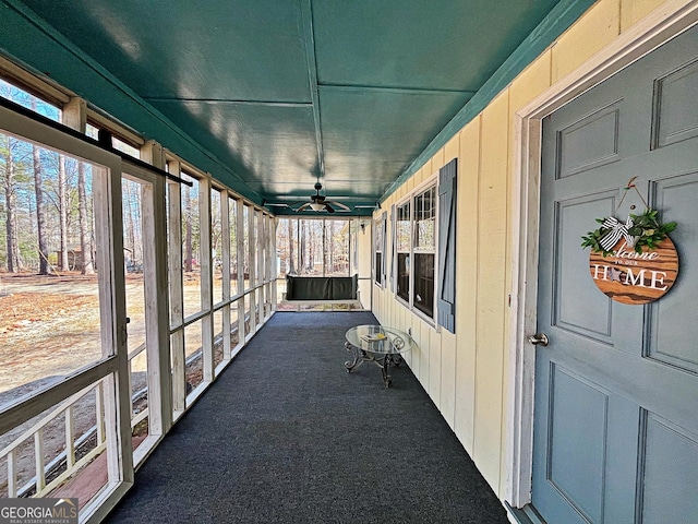 unfurnished sunroom featuring a ceiling fan