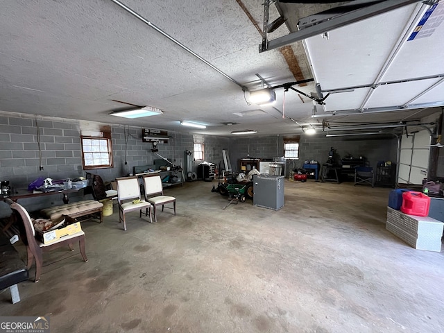 garage featuring concrete block wall and a garage door opener