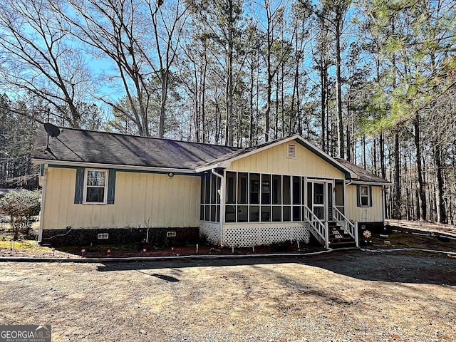 view of front of property with crawl space, roof with shingles, and a sunroom