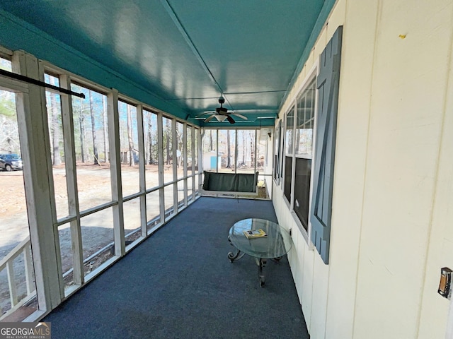 unfurnished sunroom featuring a ceiling fan