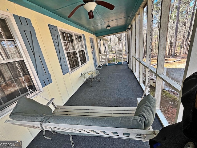 sunroom / solarium featuring a ceiling fan