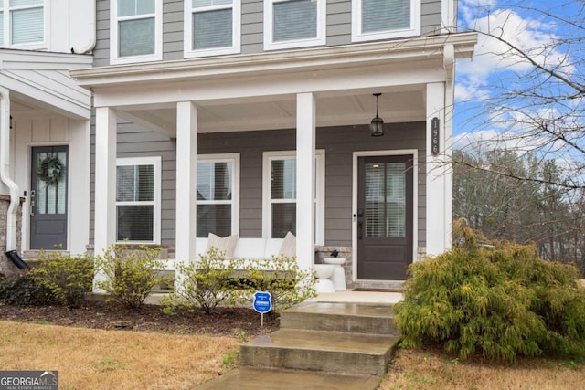 doorway to property with a porch and board and batten siding