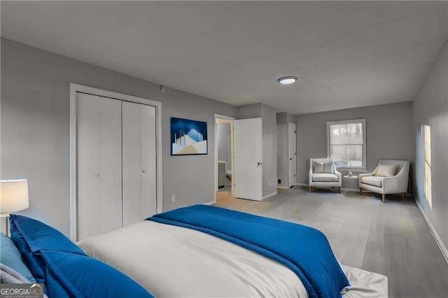 bedroom featuring a closet, baseboards, and wood finished floors