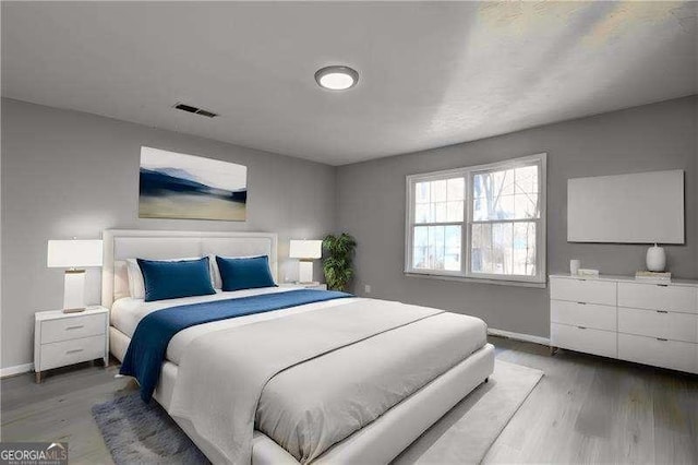 bedroom with visible vents, light wood-type flooring, and baseboards