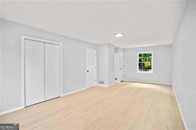 unfurnished bedroom with visible vents, baseboards, and light wood-type flooring