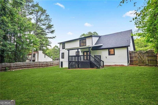 back of house featuring a lawn and fence