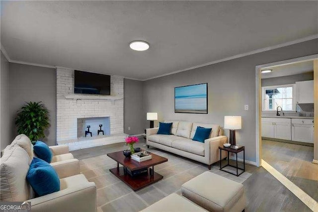 living room featuring light wood-style flooring, baseboards, a brick fireplace, and ornamental molding