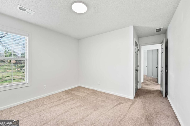 unfurnished bedroom featuring visible vents, light carpet, and baseboards