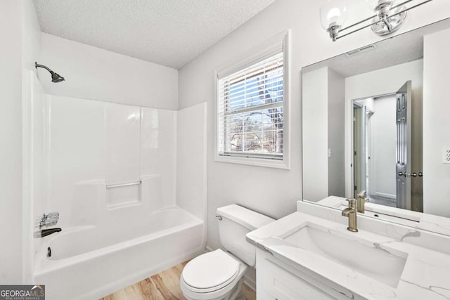 full bathroom with visible vents, toilet, a textured ceiling, wood finished floors, and vanity