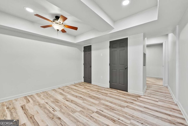 unfurnished bedroom featuring ceiling fan, baseboards, recessed lighting, wood finished floors, and a raised ceiling