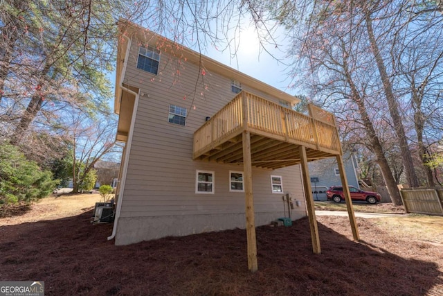 rear view of house featuring a wooden deck and central AC