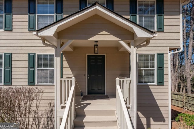 view of exterior entry featuring fence